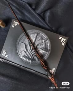 an harry potter wand and book on a black cloth