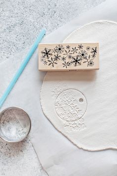 a rubber stamp with snowflakes on it next to a measuring spoon