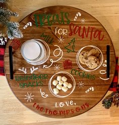 a wooden platter with cookies, milk and crackers on it that says treats for santa