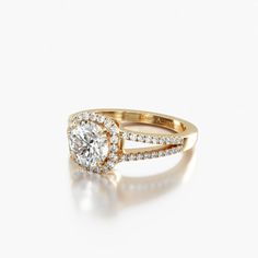 a yellow gold engagement ring with a round diamond in the center and two rows of diamonds around it