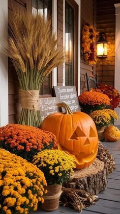 pumpkins and flowers are sitting on the porch