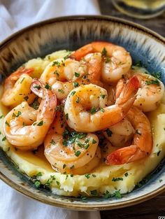 a bowl filled with shrimp and grits on top of mashed potatoes