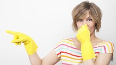 a woman wearing yellow rubber gloves is holding her thumb up