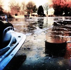 a boat is sitting on the water with ice around it and trees in the background