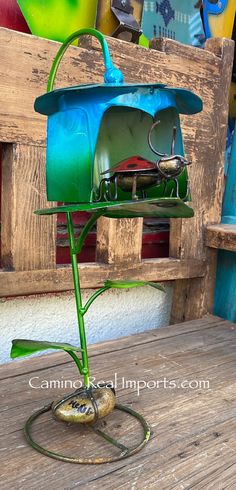 a blue birdhouse sitting on top of a wooden table