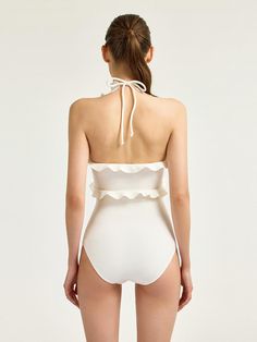 Love Hawaii monokini featuring the romantic ruffle detail and elegant halter-neckline. The bright cream color and cool texture accentuated the ruffle design, and the halter-neckline with ribbon strap gives feminine mood at the same time. We recommend style with Love Hawaii skirt to create set-up look. - Elegant halter-neckline that can adjust the depth of the neckline with the strap- Ruffle trim detail that creates voluminous silhouette- bright cream color and cool texture- Both romantic and elegant mood- Removable bra pads Feminine Halter Neck Top For The Beach, Chic Solid Color Swimwear With Ruffles, Elegant Backless Halter Top For Beach Season, Elegant White Halter Top For Vacation, Elegant Spring Swimwear With Ruffles, Feminine Sleeveless Swimwear For Pool, Cream Sleeveless Swimwear For Beach, Elegant Ruffled Swimwear For Spring, Cream Sleeveless Swimwear For Summer