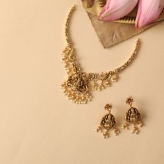 Description : Inspired by Indian temple art, this antique necklace portrays the goddess Lakshmi showering her blessings among floral & bird patterns. Handcrafted in the Nakshi style and embellished with kempu stones and pearl drop beads to enhance your festive look. Details & Specifications:Materials used: Brass Alloy with Antique platingWeight - Necklace: 48.95 gms, Earrings: 25.2 gmsLength - Necklace: 15 cms, Earrings: 6 cmsMake it customWant to make it a custom necklace? Sure! Reach out to us Festive Temple Jewelry Necklace With Peacock Design, Spiritual Peacock Design Necklaces For Festivals, Spiritual Peacock Design Necklace For Festivals, Kundan Temple Necklace With Peacock Design For Rituals, Peacock Design Necklace For Puja And Navratri, Peacock Design Necklace For Navratri Puja, Navratri Puja Peacock Design Necklace, Spiritual Temple Necklace For Celebrations, Spiritual Kundan Necklace For Festive Celebration