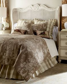 a bed with brown and white comforters in a bedroom