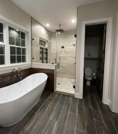 a bathroom with a large white bathtub next to a walk in shower