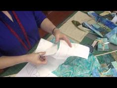 a woman is cutting fabric with scissors