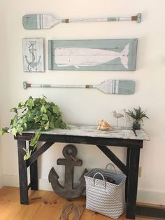 an anchor, plant and two paddles are displayed on the wall above a table