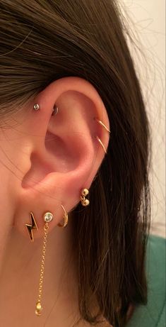 a close up of a person with ear piercings on their ears and behind the ear