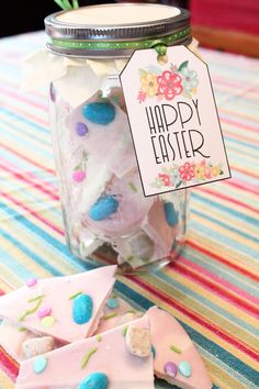 an easter gift in a jar with some candy on it and the tag that says happy easter