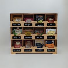 a wooden shelf with several different types of food on it and chalkboard labels attached to the shelves