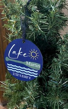 a blue ornament hanging from the side of a tree with water and sun on it