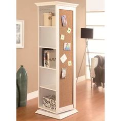 a tall white bookcase with cork and memos on the front, in a living room