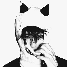 black and white photograph of a person with cat ears on their head, covering his face