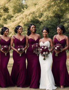 a group of women standing next to each other wearing dresses and holding bouquets in their hands