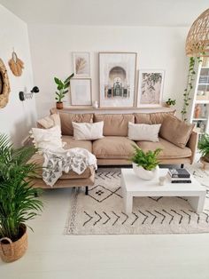 a living room filled with lots of furniture and plants on top of a white rug