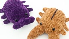 two crocheted stuffed animals sitting next to each other on a white surface,