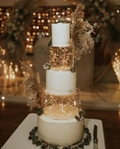 a three tiered wedding cake with feathers on top