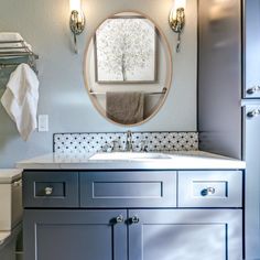 a bathroom with a sink, mirror and towel rack on the wall next to it