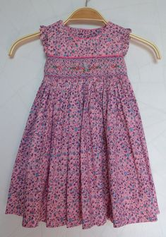 Pretty pink flowery girl dress. It is finely embroidered by hand on the front. A smock dress in a beautiful 100% cotton fabric. Dress to wear on all occasions. Exists from 3 months to 10 years Cotton Sundress With Smocked Bodice For Garden Party, Pink Embroidered Dress With Floral Print For Garden Party, Cotton Smocked Dress With Floral Print For Beach, Cute Cotton Smocked Dress, Pink Sundress With Smocked Bodice, Summer Smocked Dress With Floral Embroidery For Garden Party, Floral Embroidered Smocked Dress For Summer Garden Party, Summer Floral Embroidered Smocked Dress For Garden Party, Pink Cotton Embroidered Dress For Spring