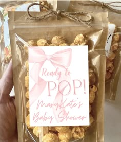 a bag of baby shower popcorn with a pink bow on it's ribbon and the words ready to pop