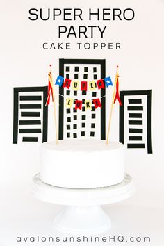 a white cake with flags on it and the words super hero party written in black