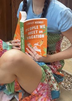 a woman sitting on the ground reading a book