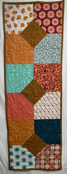 a patchwork quilt is hanging on the wall