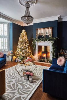 a living room filled with furniture and a christmas tree in front of a fire place