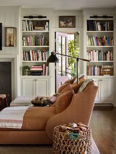 a living room filled with lots of furniture and bookshelves