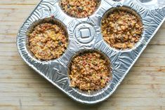 four muffin tins sitting on top of a wooden table