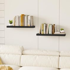 two bookshelves on the wall above a white couch