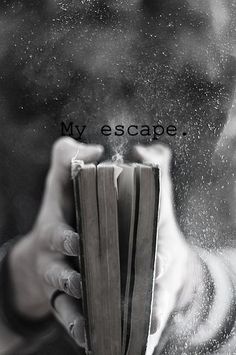 a person holding an open book in their hand with dust coming out of the pages