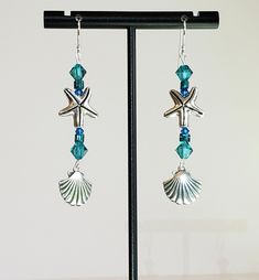 "- \"Beach Bedazzled\" is our 2 1/4\" dangling Earring beauty with the Beach in mind. See Photos #1-4. - 925 Sterling Silver Scallop Shell pairs with Sterling Silver Plated Starfish and several Swarovski Faceted Bicone Crystals in Turquoise and Teal Blue shades. - Crystals are in a Teal Blue, Blue Zircon & Capri Blue shade with Glass Seed Beads in Blue/Green. There is a hint of Green in the Blue Zircon Crystals. We are talking serious Caribbean colors here! - 925 Sterling Silver Filled Bali Ocean-inspired Starfish Dangle Jewelry, Turquoise Dangle Earrings With Ocean-inspired Style, Turquoise Dangle Earrings Ocean-inspired, Ocean-inspired Turquoise Dangle Jewelry, Silver Drop Earrings With Starfish Charm, Sterling Silver Starfish Charm Dangle Earrings, Silver Ocean-inspired Earrings With Starfish Charm, Ocean-inspired Silver Earrings With Starfish Charm, Summer Starfish Charm Dangle Jewelry