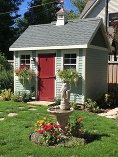 a small garden shed with a fountain in the front yard