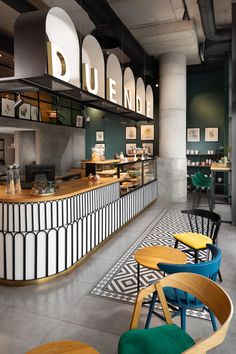 the interior of a restaurant with colorful chairs and counter tops, along with black and white tiles