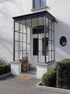 a white brick building with black trim and glass windows on the front door is shown