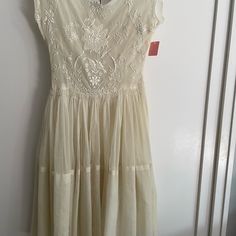 a white dress hanging on a door with a tag attached to the back of it