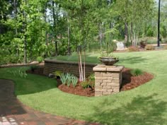 a brick wall in the middle of a grassy area