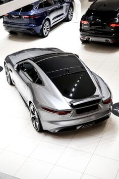 three different models of cars on display in a showroom with white tile flooring