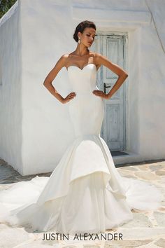 a woman in a white wedding dress posing for the camera