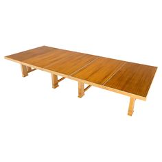 a large wooden table with no one around it on a white background in front of a white backdrop