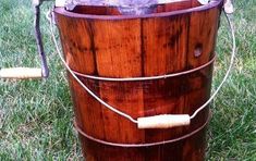 an old wooden bucket sitting in the grass