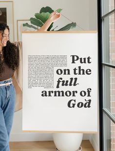 a woman standing next to a sign that says put on the full armor of god