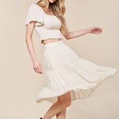 Elevate Your Summer Style With Our Woven Skirt Set In White! The Crop Top Features A Flattering Square Neckline And Smocking For A Perfect Fit, While The Flowy Sleeves And Ruffle Detail Add A Touch Of Charm. The Midi Skirt Has An Elastic Waistband And Lace Trim For A Feminine Touch, And Is Fully Lined For Comfort. Made Of 100% Rayon And 100% Polyester Lining. Model Is 5'8" And Wearing A Size Small. Fit: True To Size Pockets Skirt Lined Rayon White Rayon Skirt For Summer, White Rayon Summer Skirt, Casual Ruffled Rayon Skirt, Solid Rayon Skirt For Summer, Summer Off White Tiered Skirt, Summer Off-white Tiered Skirt, Off White Tiered Skirt For Spring, Off White Tiered Skirt For Summer, Spring Off-white Tiered Skirt