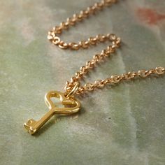 "Shop for the Charmalong™ 14K Gold Plated Heart Key Charm by Bead Landing™ at Michaels. Accentuate your custom necklace with this gold heart-shaped key charm by Bead Landing. Accentuate your custom necklace with this gold heart-shaped key charm by Bead Landing. Add this charm to a gold-toned chain to complete your jewelry project. Details: 14K gold plated 0.91\" x 0.39\" x 0.2\" (23.1mm x 9.9mm x 6mm) Nickel free Zinc alloy and iron | Charmalong™ 14K Gold Plated Heart Key Charm by Bead Landing™ Gold Heart Necklace With Two Keys, Bead Landing, Heart Key, Heart And Key, Custom Necklace, Jewelry Projects, Heart Of Gold, Zinc Alloy, Gold Necklace