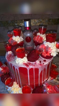 a red and white cake topped with lots of frosting on top of a table